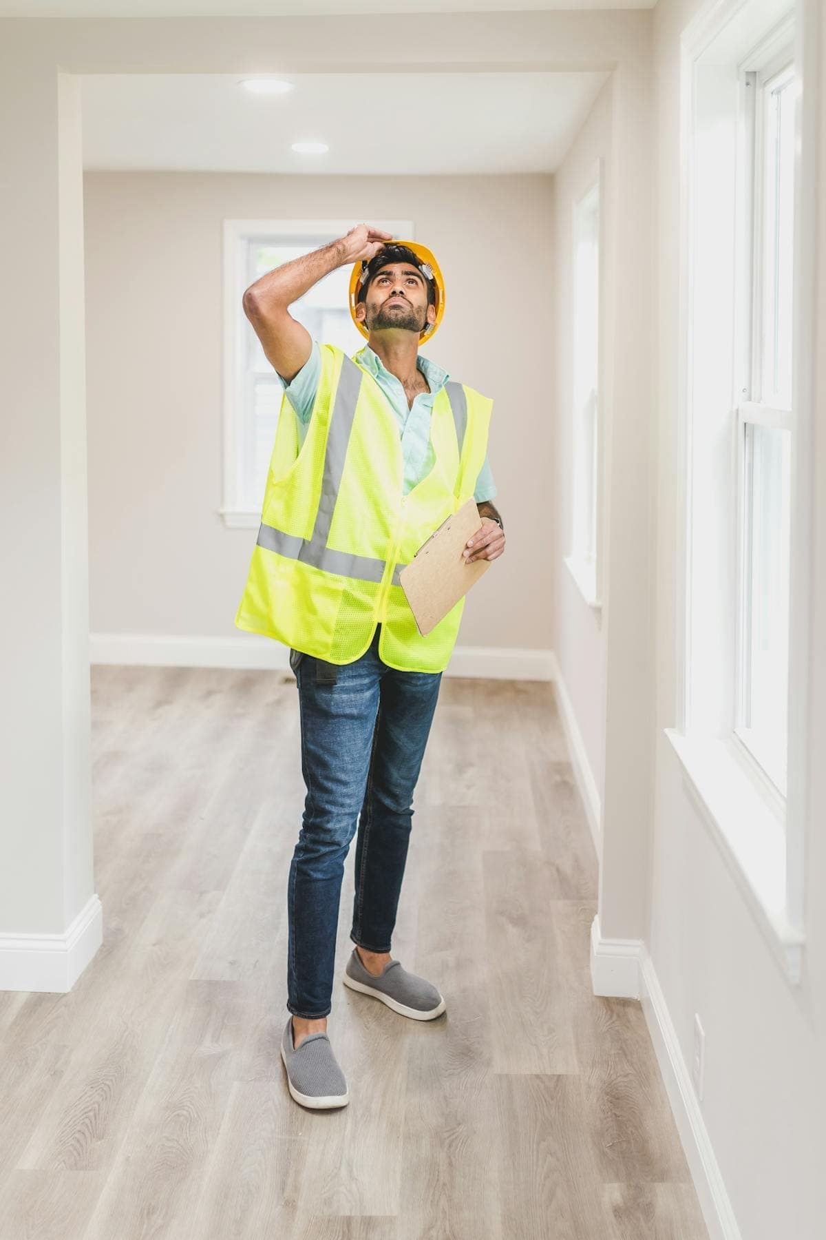 Inspector in safety vest examining house interior for mold and damage