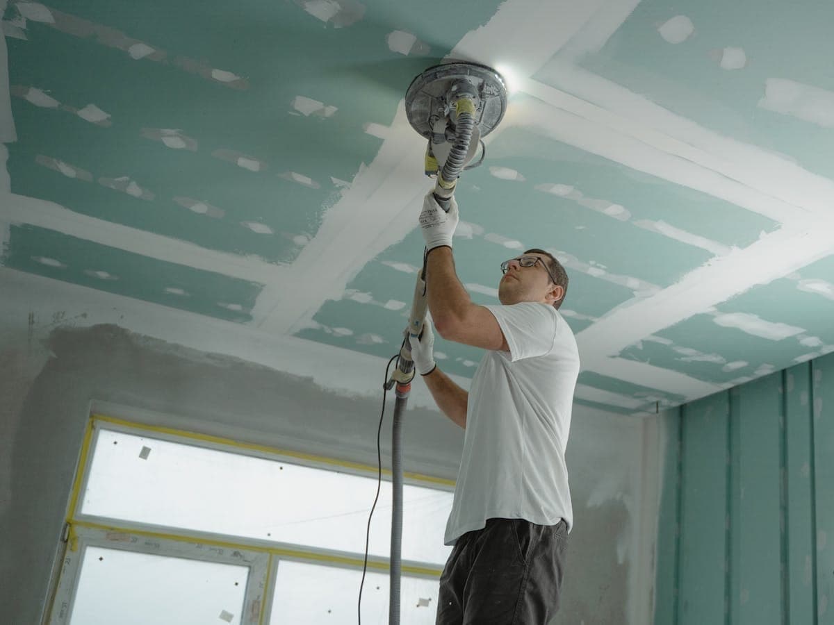 Interior of a Frisco, Texas home showing water damage from a slab leak, with standing water near the foundation and a dehumidifier in place during professional restoration