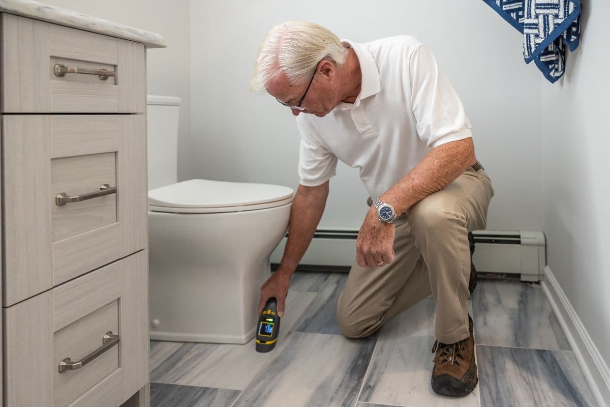 Professional moisture inspection in a Dallas home using thermal imaging camera to detect hidden water damage behind walls and under flooring