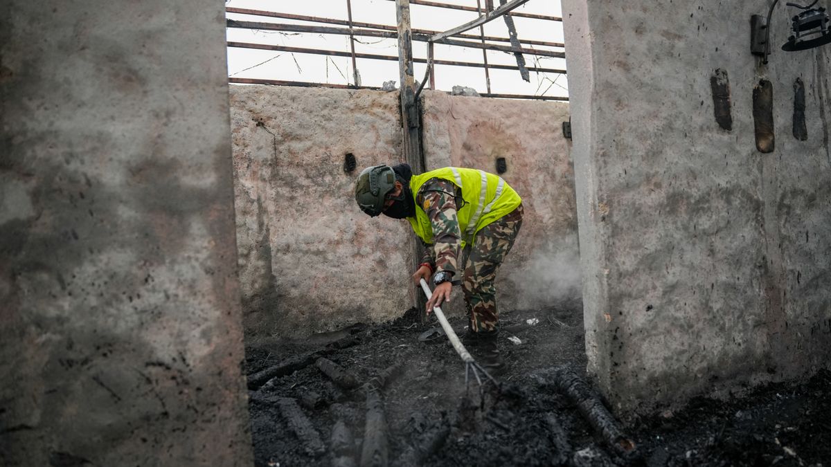 Fire restoration worker in protective gear cleaning debris during the aftermath of a structural fire cleanup